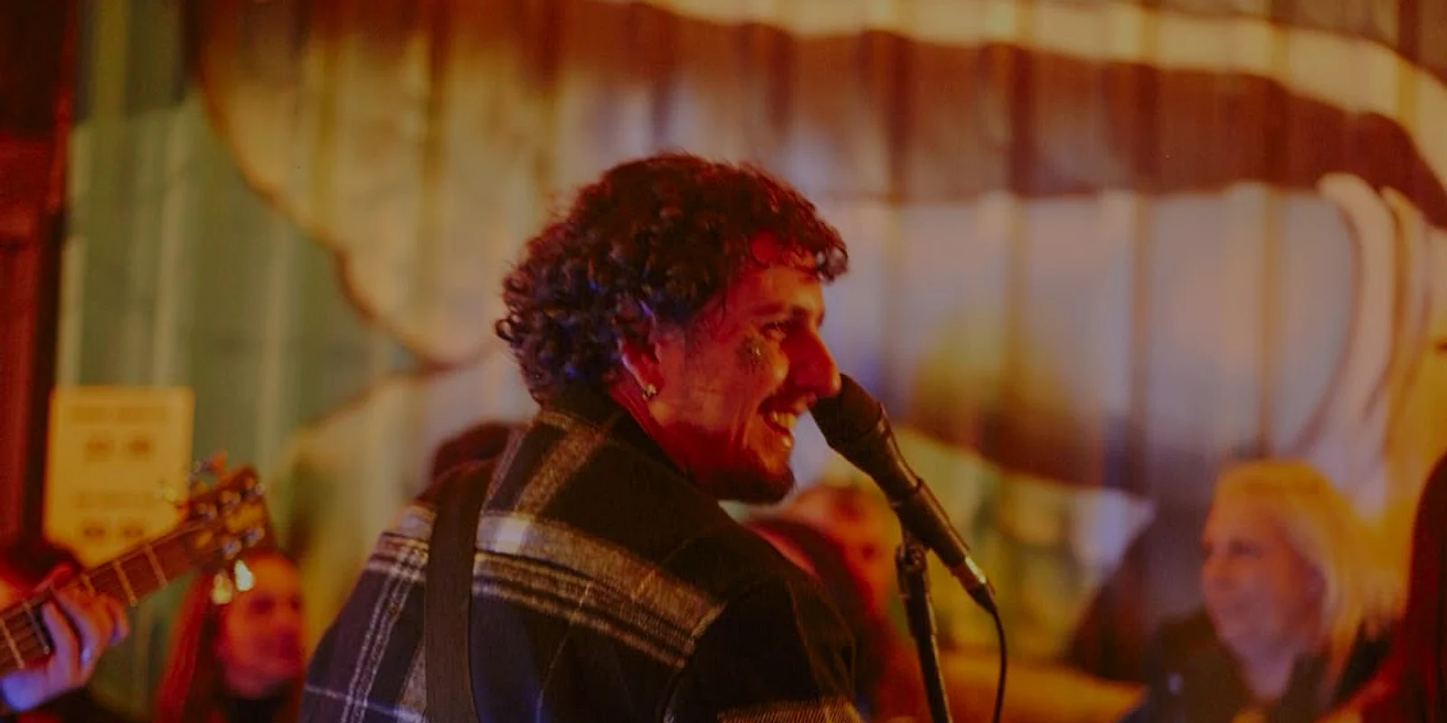 Banda tocando ao vivo no PUGA, o vocalista no microfone com a casa em volta